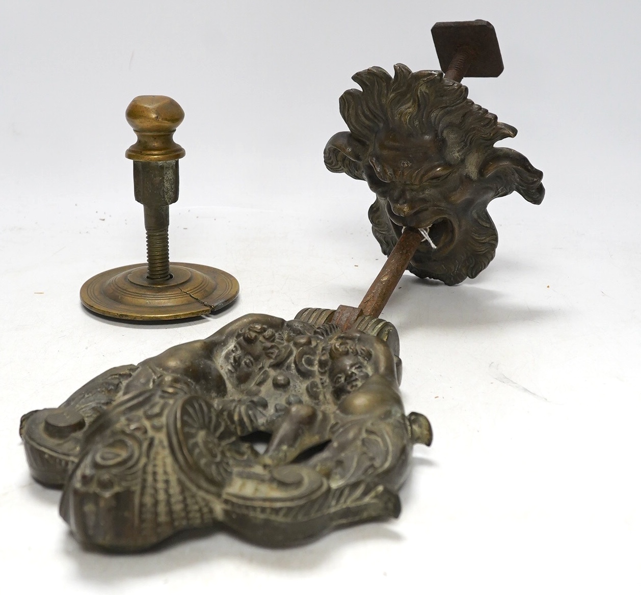 An Italian bronze satyr door knocker, circa 1700, together with a brass handle, knocker drop 22cm. Condition - fair